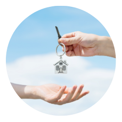 A house key being handed from one person to another.